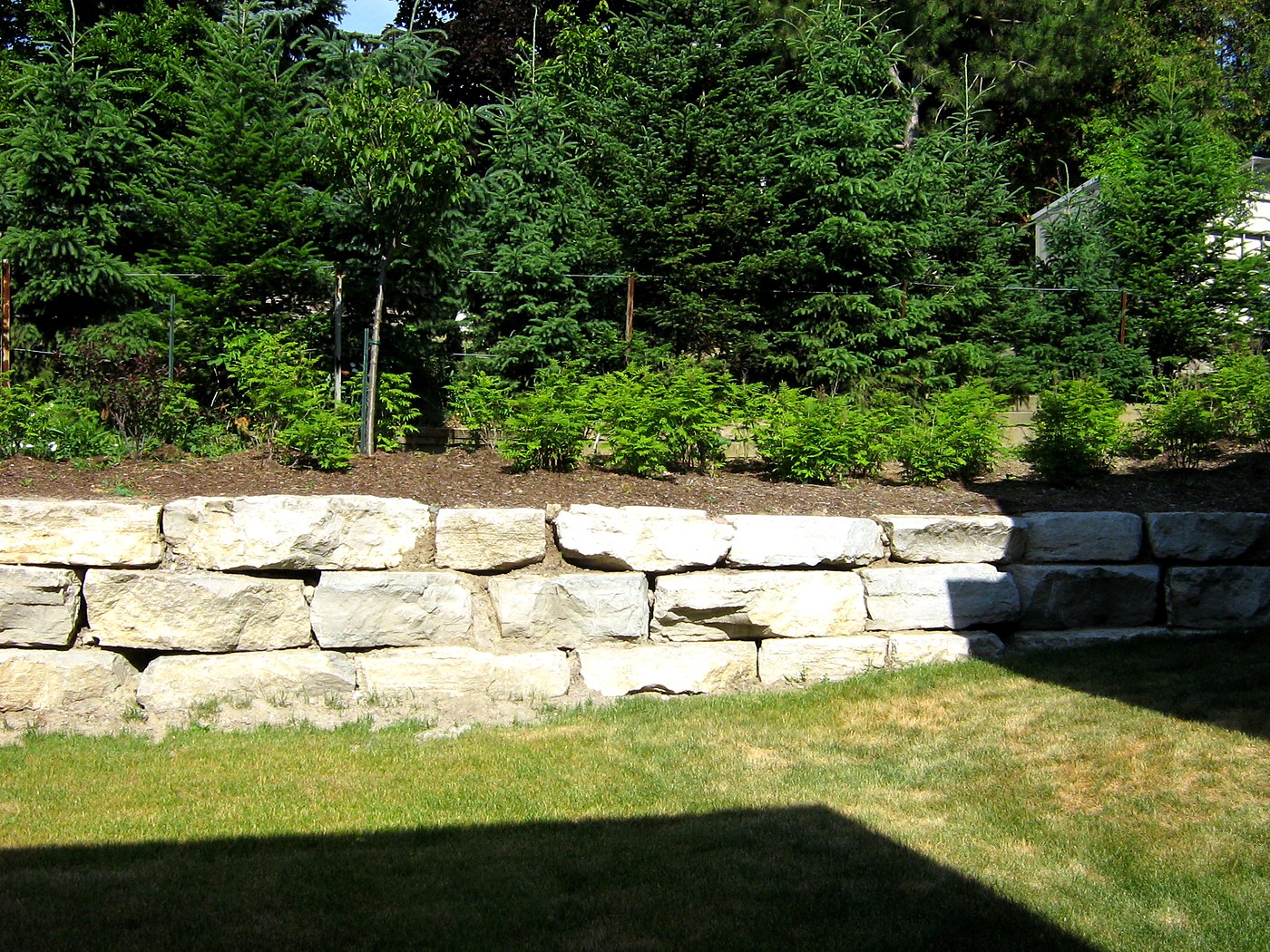 Armourstone retaining wall with landscaping
