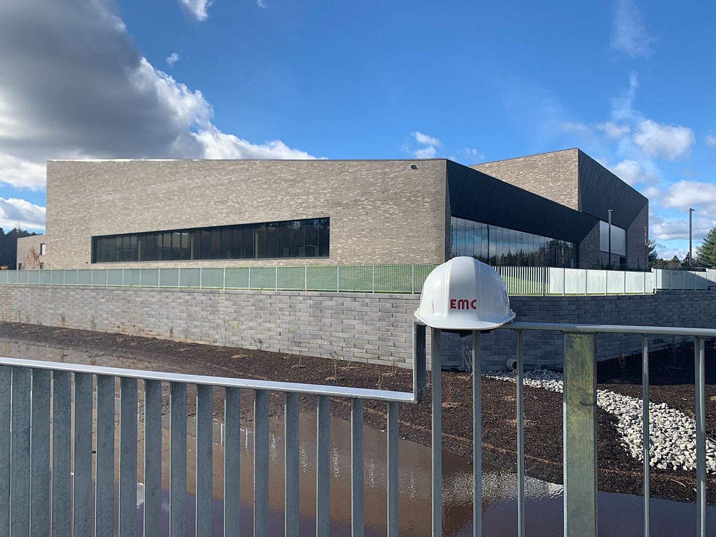 EMC hardhat overlooking SWM pond area and completed building