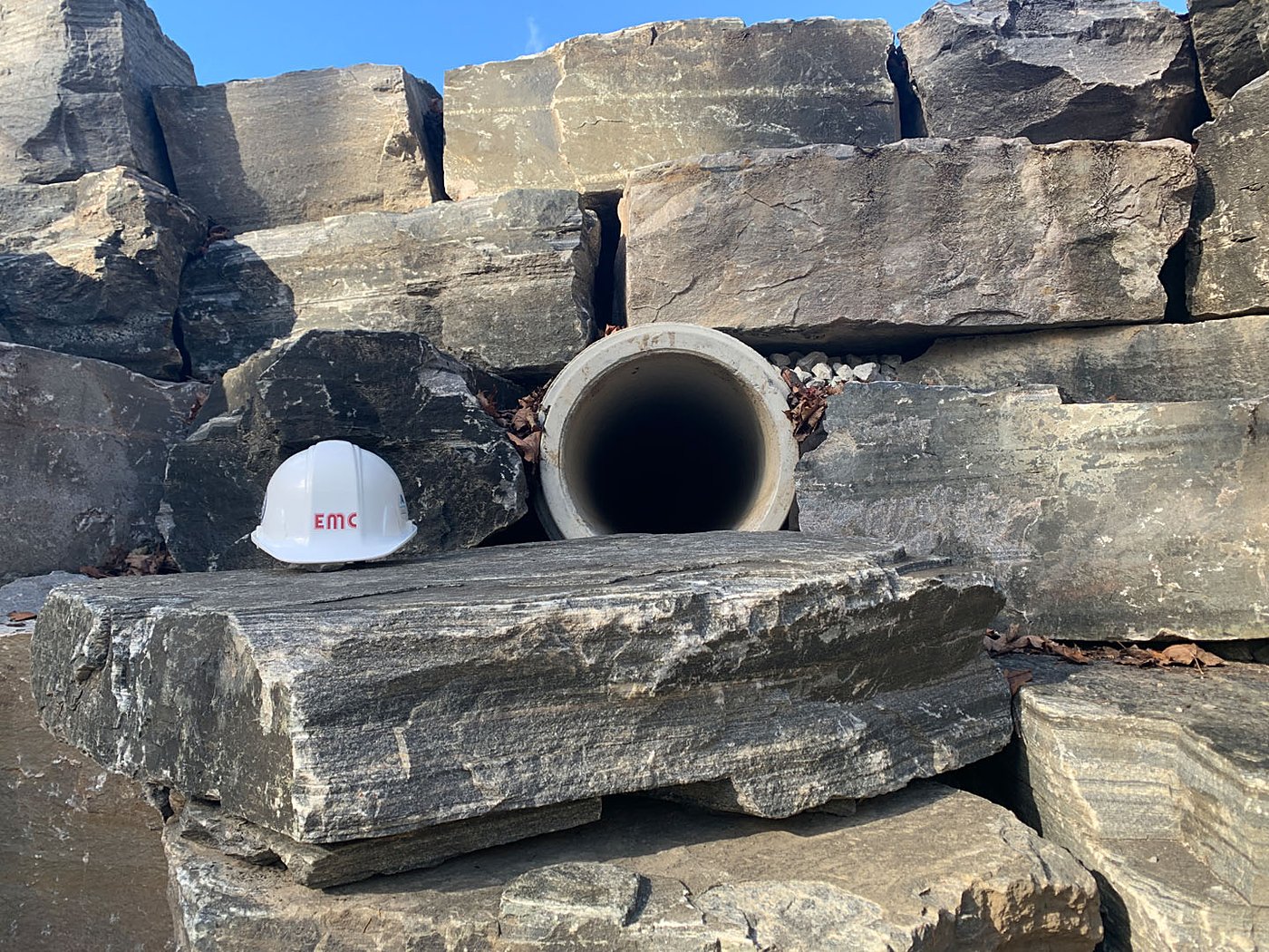 Retaining wall close-up with EMC hardhat and pipe outfall