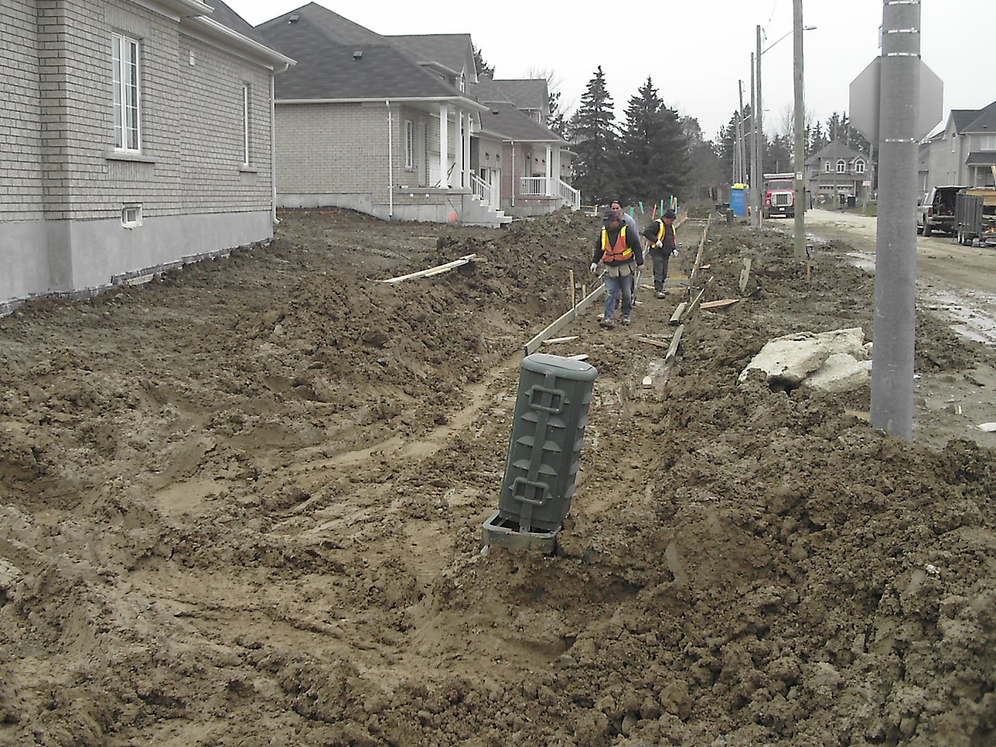 Workers installing catch basin along residential boulevard