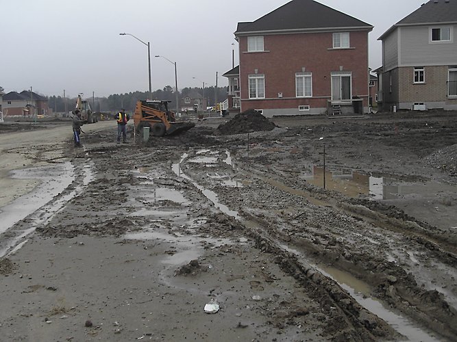 Excavator grading residential boulevard