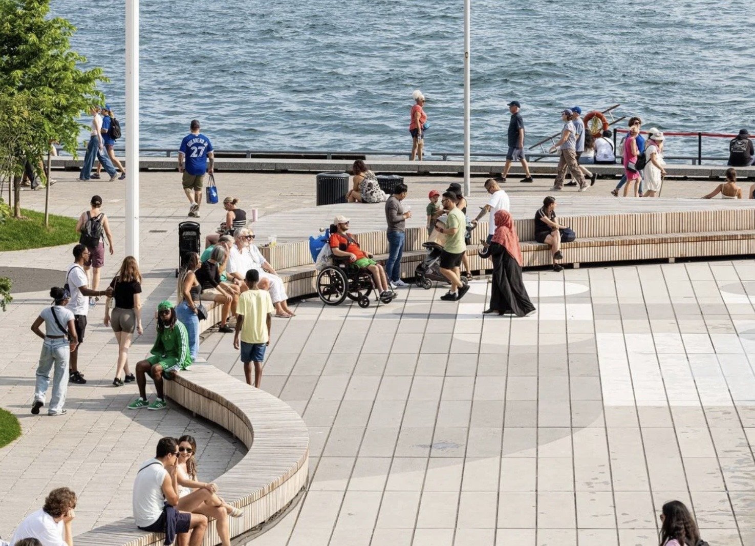 Harbourfront Centre Community Square – Crowds on the paved plaza and curved timber benches with Lake Ontario behind