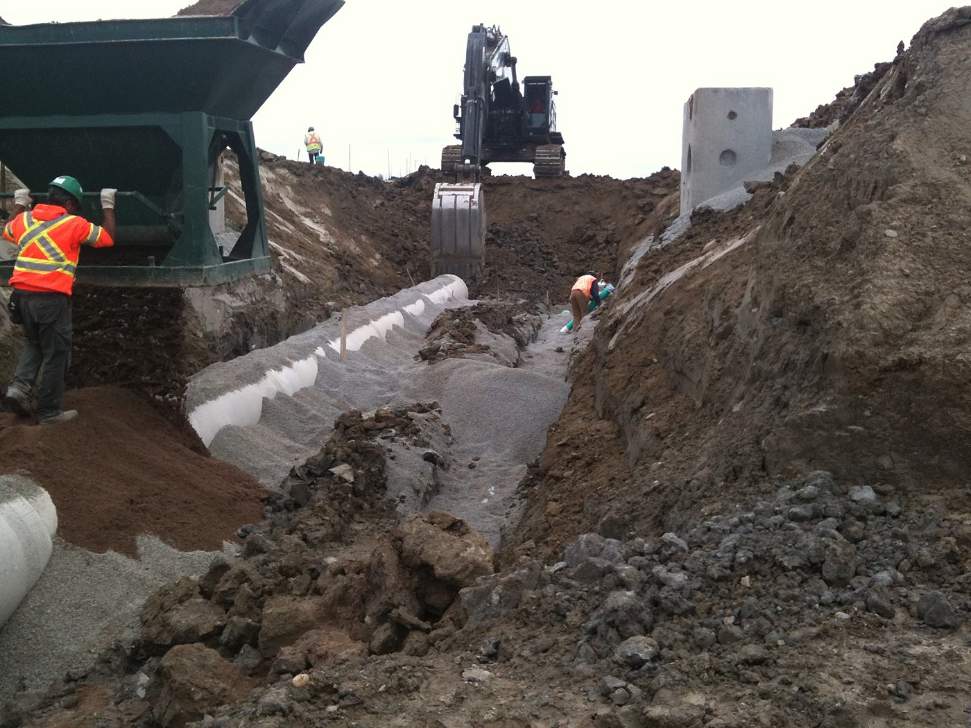 Excavator and dump truck during storm pipe installation