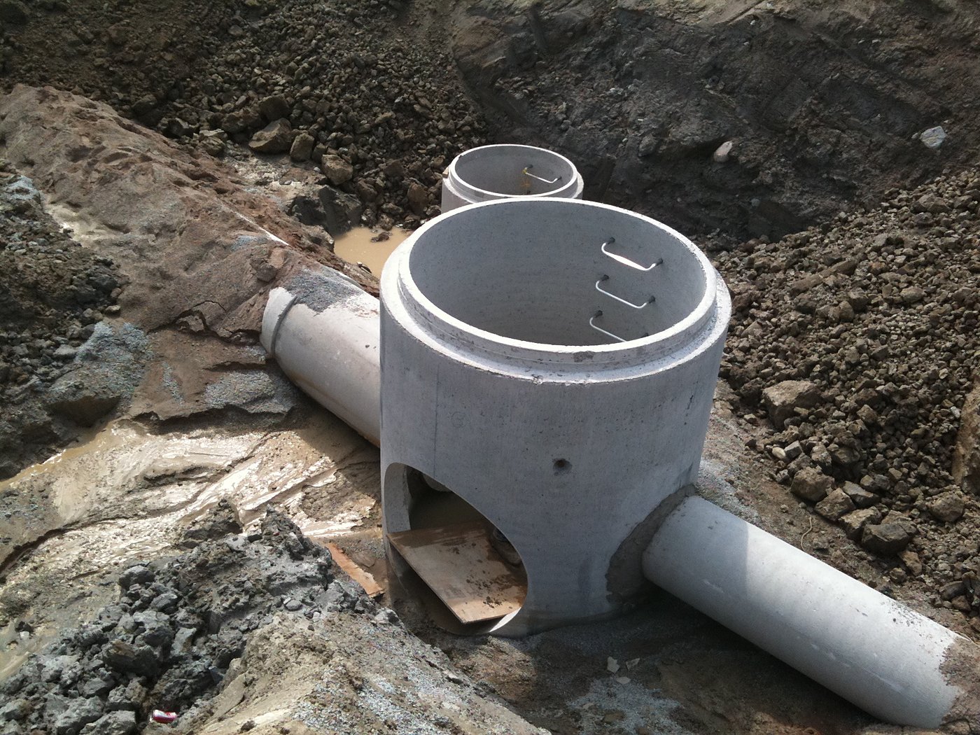 Concrete storm manhole junction with pipes