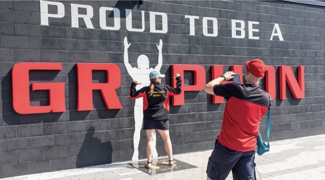 University of Guelph – Alumni Stadium – Fans photographing each other at the Proud to be a Gryphon wall