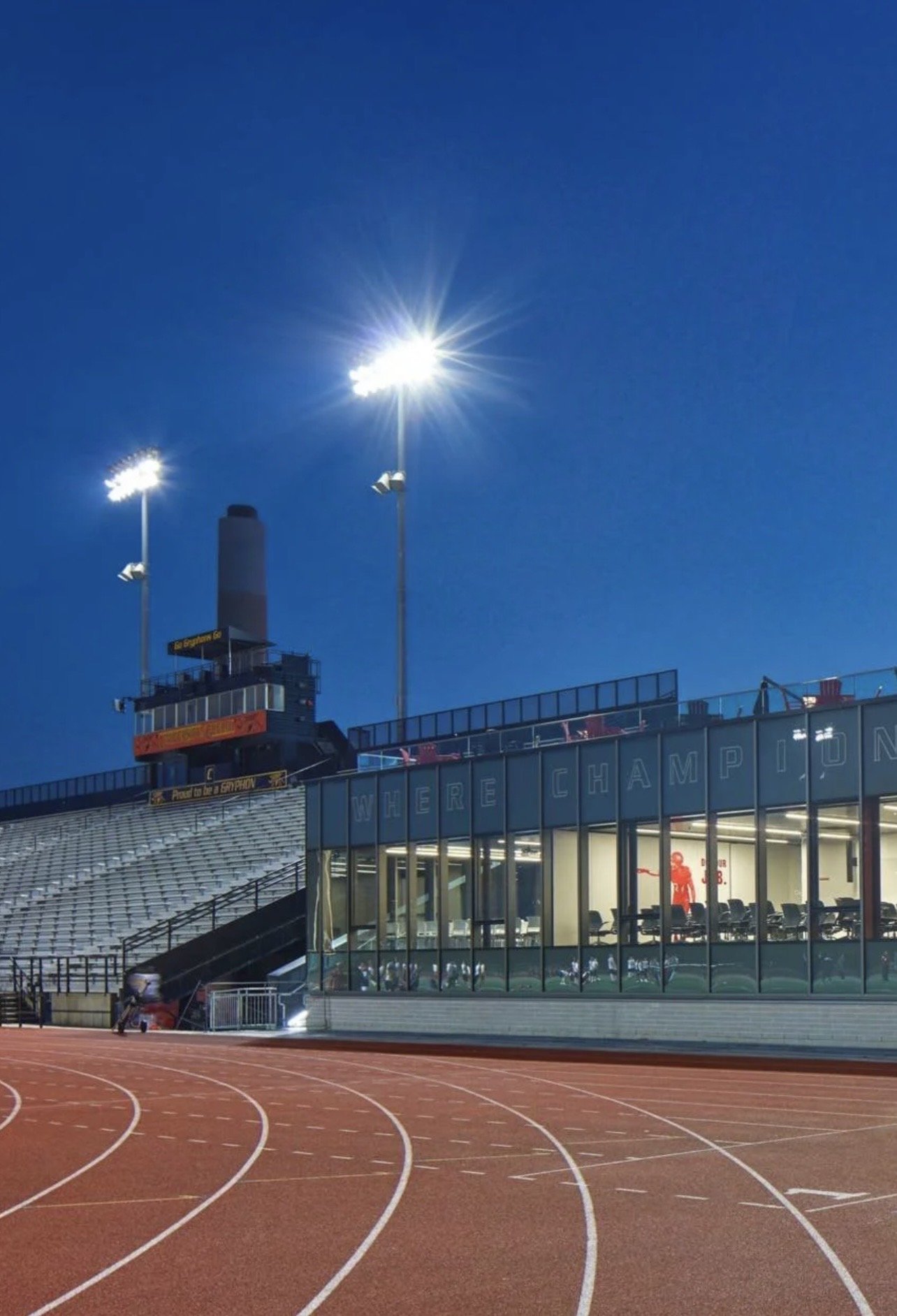 University of Guelph – Alumni Stadium – Running track curve in front of the grandstand and lit Gryphon Football Pavilion at night