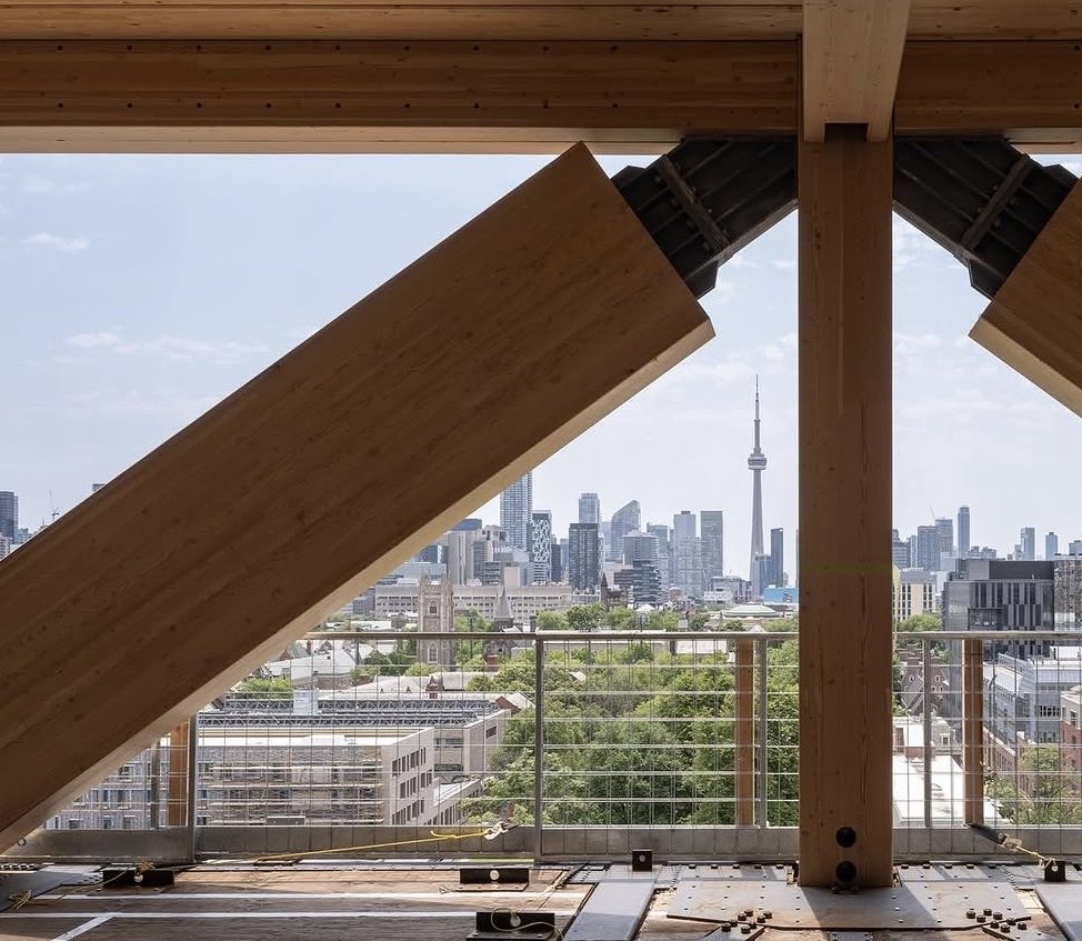 University of Toronto – Academic Tall Wood Tower – Mass-timber diagonal braces on an upper floor with the CN Tower and downtown skyline beyond